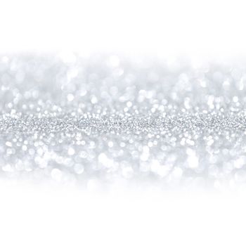 Silver festive glitter background with defocused lights