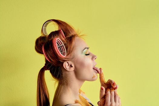 Young redhead woman with shugaring paste on her hands, face, body and chest. Young redhead woman with hair curlers. Advertising concept of shugaring paste. Skin care concept with copyspace.