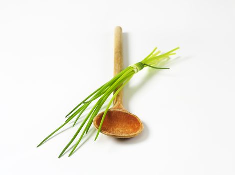 Bunch of fresh chives and wooden spoon