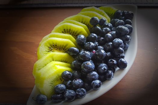 White smoothie bowl with kiwi and blueberry - blueberries, pickup with vignetting