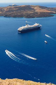 Typical view from Fira village to caldera sea with cruise ship at sunset, Santorini island, Greece