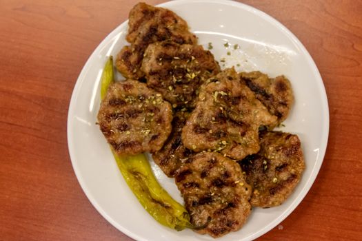 an isolated upper view shoot to meat and some fried pepper. this food photo has taken at a restaurant.