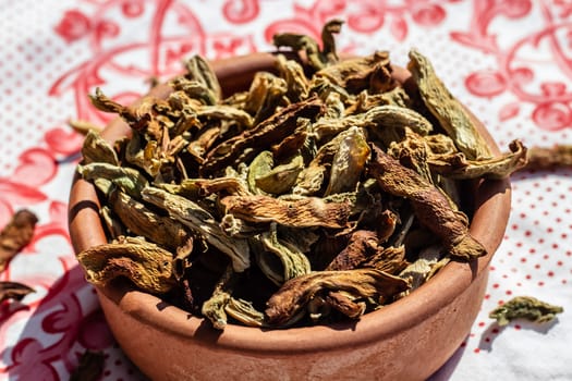 an upper view closeup food shoot to messy dried peppers with round clay bowl. photo has taken at a village at turkey.