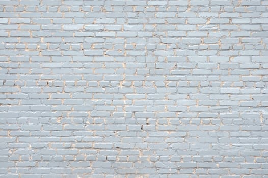 Old brick wall, painted in violet close-up. The photo was taken under the open sky, cloudy day.