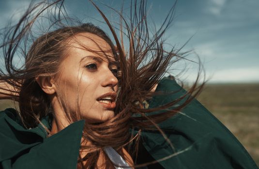 Woman outdoors with tousled wind blown hairs 