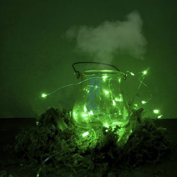Magic cauldron, green background, moss, firefly, fog smoke bokeh close-up