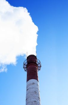 Big pipe from steamshop with white steam against blue sky