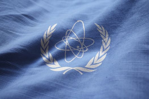 Closeup of Ruffled International Atomic Energy Agency Flag, IAEA Flag Blowing in Wind