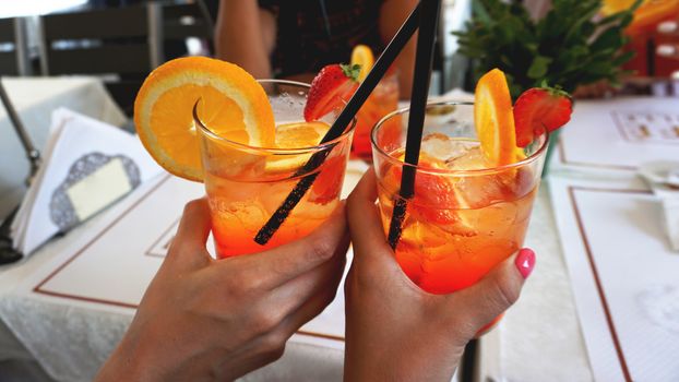 Young cheerful couple drinking Aperol Spritz cocktail in cafe in Milan