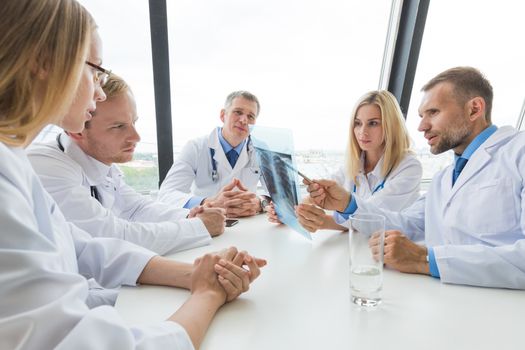 medical colleagues discuss x-ray sitting at the office table