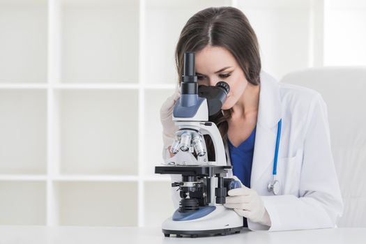 Young scientist with microscope in a laboratory doing some research