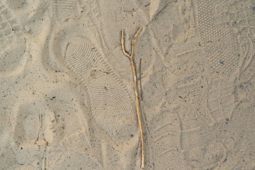 Sand on the beach with footprints and shoes. Many footprints with shoes and without shoes.