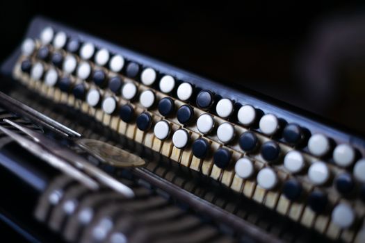 The old rare accordion buttons close up view. Low light photo.