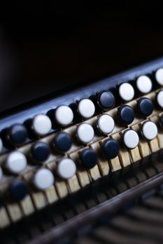 The old rare accordion buttons close up view. Low light photo.