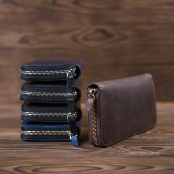 Five handmade leather porte-monnaie on wooden textured background.  Side view. Stock photo of luxury accessories with blurred background..