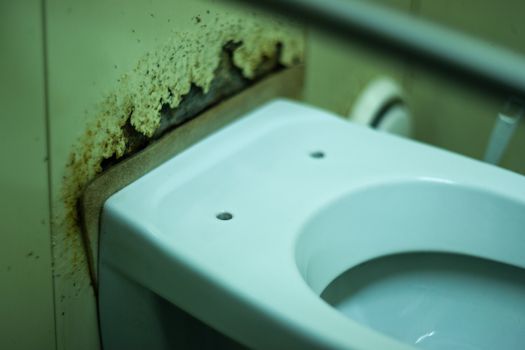 Dirty terrible toilet in a public toilet. Plating deteriorated from moisture and urine