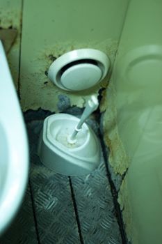 Dirty terrible toilet in a public toilet. Plating deteriorated from moisture and urine