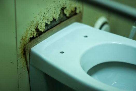 Dirty terrible toilet in a public toilet. Plating deteriorated from moisture and urine