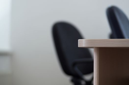 Office desk corner, in the background office chairs, no people