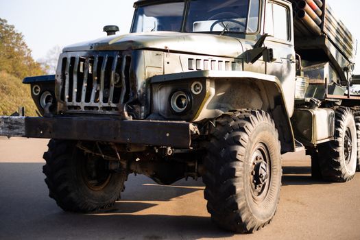 Camouflage military truck with rocket launcher. Outdoor military vehicles museum. Armor is damaged at the battlefield.