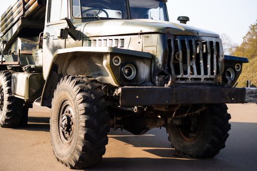 Camouflage military truck with rocket launcher. Outdoor military vehicles museum. Armor is damaged at the battlefield.