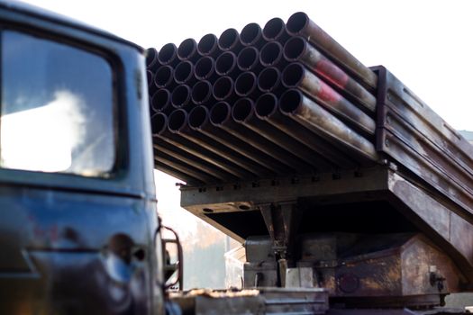 Camouflage military truck with rocket launcher. Outdoor military vehicles museum. Armor is damaged at the battlefield.