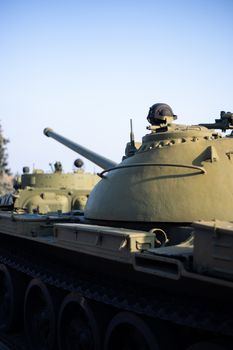 Parts of the hull of the armored old tank. In front and back of tank stays many different tanks. Parts closeup. Military equipment outdoor open air museum.