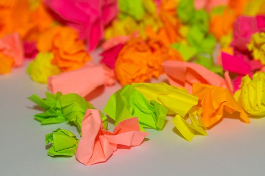 Bright crumpled multi-colored stickers on the office white board.