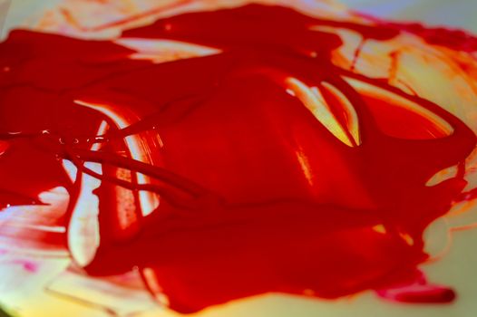 Hue red acrylic paint on glare table. Palette on table. Artist life.