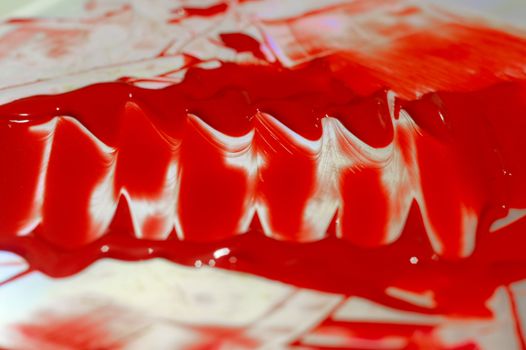 Hue red acrylic paint on glare table. Palette on table. Artist life.