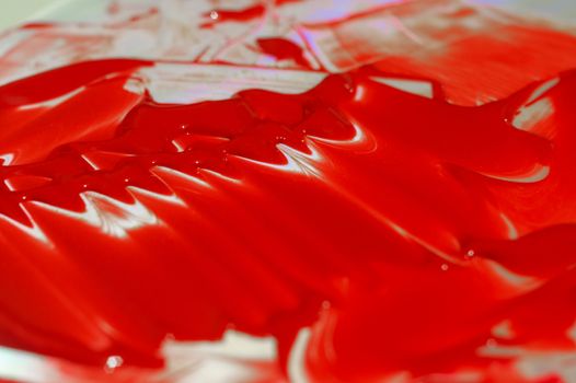 Hue red acrylic paint on glare table. Palette on table. Artist life.