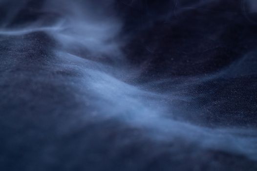 White smoke on black fabric background. Smoke spreads over the background. Vaping culture, life without cigarettes. Conceptual image.