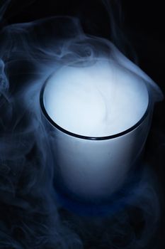 White smoke on black fabric background in glass. Smoke spreads over the background. Vaping culture, life without cigarettes. Conceptual image.