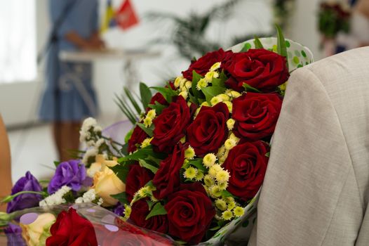 Bouquet of roses in man hands. Weddind details in closeup view. Solemn event.