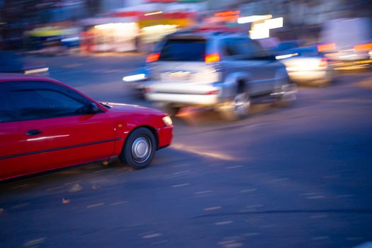 Motion blur red car photo on crossroad. Soft focus photo. Night big city life