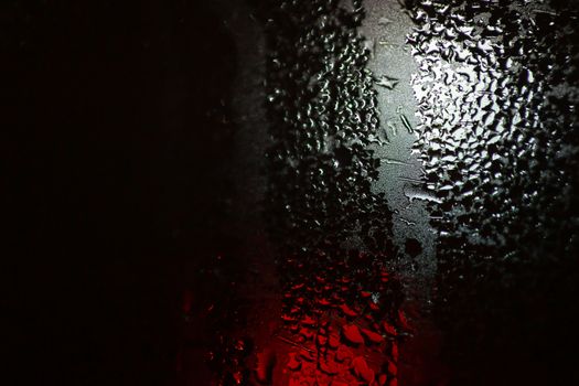 Night colorful big city lights through car windshield.

Light are defocused and blurred. Focus on windshield. Underexposed photo.