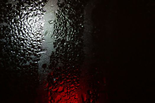 Night colorful big city lights through car windshield.

Light are defocused and blurred. Focus on windshield. Underexposed photo.