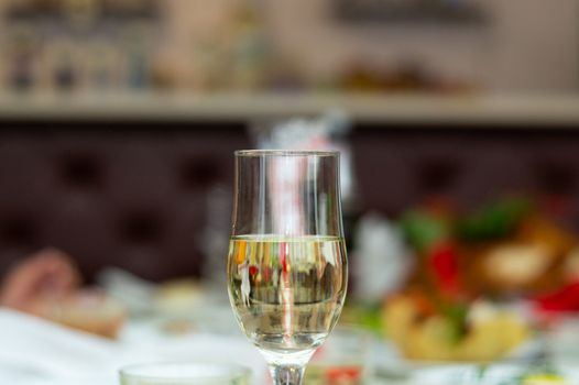 Glass with bubbly champagne in weddind. Wedding details in close-up view.