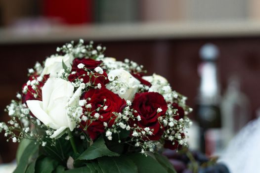 Bouquet of roses in bride hands. Weddind details in closeup view. Solemn event.