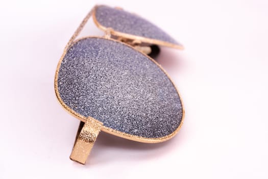 Sunglasses with artificial snow on white background close-up view.