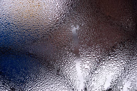 Water drops on glass window close up with blurred background. Drops in macro. Condensate on window closeup. Wet air.