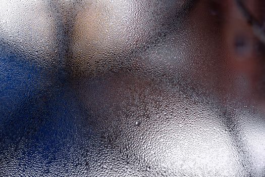 Water drops on glass window close up with blurred background. Drops in macro. Condensate on window closeup. Wet air.