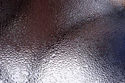Water drops on glass window close up with blurred background. Drops in macro. Condensate on window closeup. Wet air.