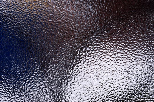 Water drops on glass window close up with blurred background. Drops in macro. Condensate on window closeup. Wet air.