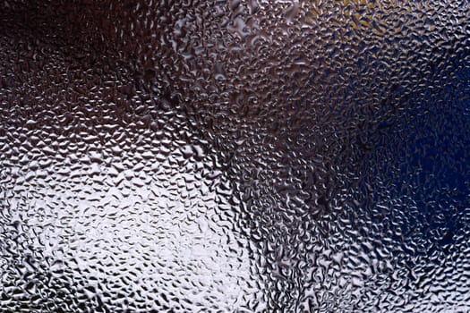 Water drops on glass window close up with blurred background. Drops in macro. Condensate on window closeup. Wet air.