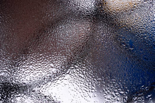 Water drops on glass window close up with blurred background. Drops in macro. Condensate on window closeup. Wet air.