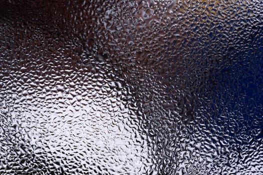 Water drops on glass window close up with blurred background. Drops in macro. Condensate on window closeup. Wet air.