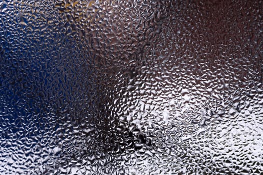 Water drops on glass window close up with blurred background. Drops in macro. Condensate on window closeup. Wet air.