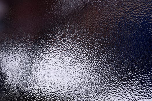 Water drops on glass window close up with blurred background. Drops in macro. Condensate on window closeup. Wet air.