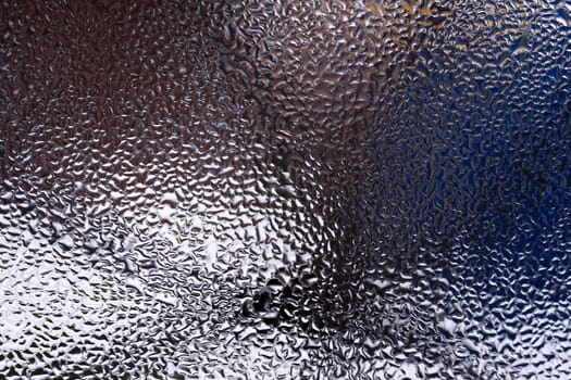 Water drops on glass window close up with blurred background. Drops in macro. Condensate on window closeup. Wet air.